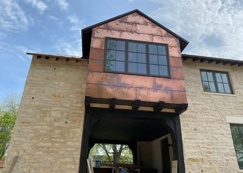 Copper metal panel facade on a stone building for Roof Repair in Sheridan